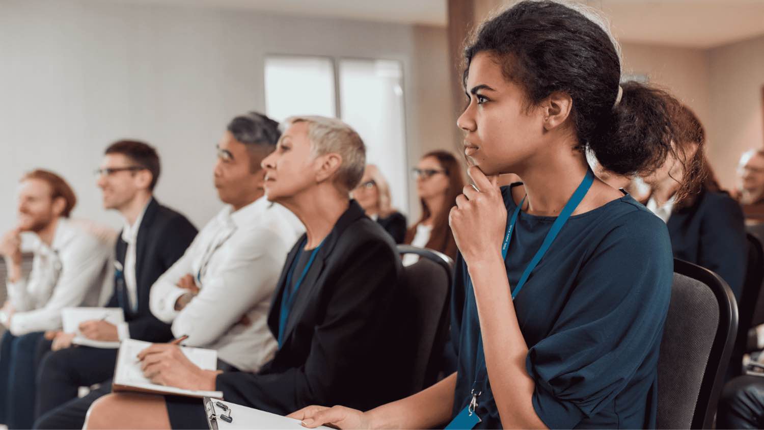 Professionals taking notes in a lecture